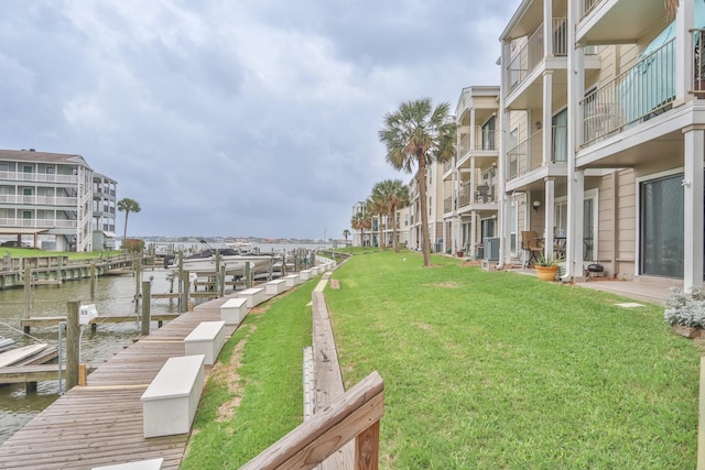 dock area featuring a balcony, a yard, and a water view