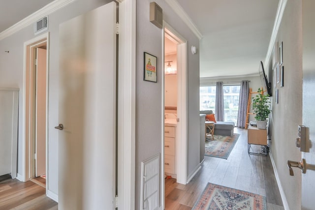 hall featuring light hardwood / wood-style flooring and crown molding