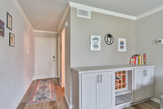 corridor featuring light wood-type flooring and crown molding