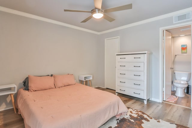 bedroom featuring ceiling fan, wood-type flooring, ensuite bath, and crown molding