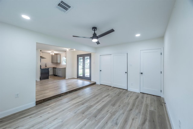 interior space with ceiling fan, french doors, and light wood-type flooring