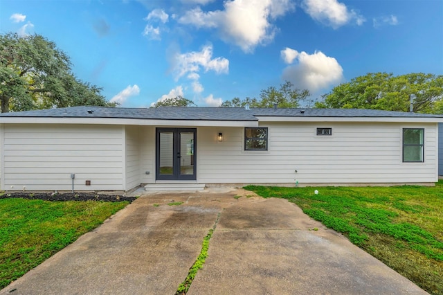 back of house featuring a yard and french doors