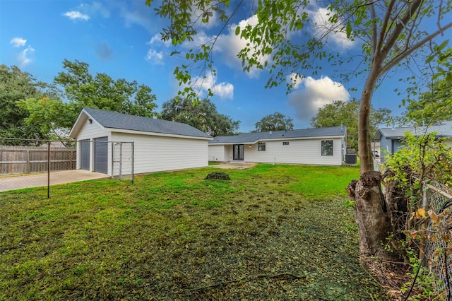 back of property featuring an outbuilding, a garage, and a lawn