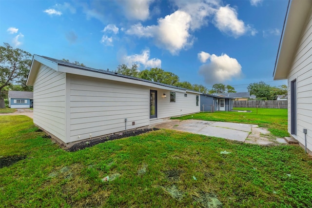 back of property with a yard and a patio