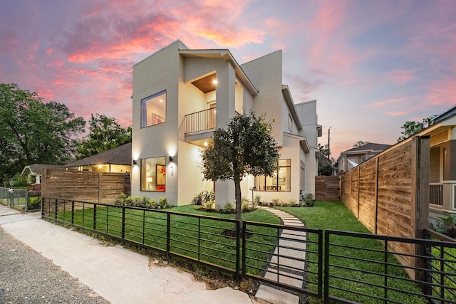 contemporary house with a balcony and a yard