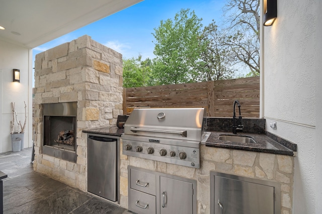 view of patio / terrace featuring area for grilling, sink, grilling area, and an outdoor stone fireplace