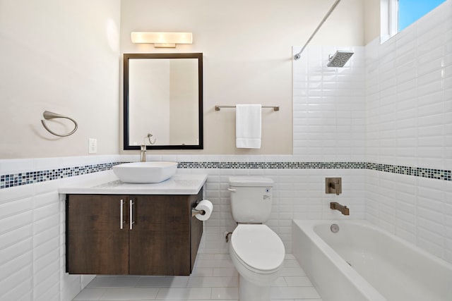 full bathroom featuring washtub / shower combination, tile walls, vanity, tile patterned floors, and toilet