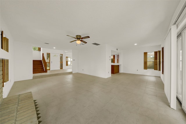 unfurnished living room with a healthy amount of sunlight, ceiling fan, and light tile patterned flooring