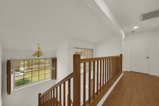 hallway with hardwood / wood-style flooring and lofted ceiling