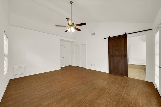 3327 Larkwood Ln, Sugar Land, TX 77479 - unfurnished bedroom with a barn door, high vaulted ceiling, a ceiling fan, and baseboards