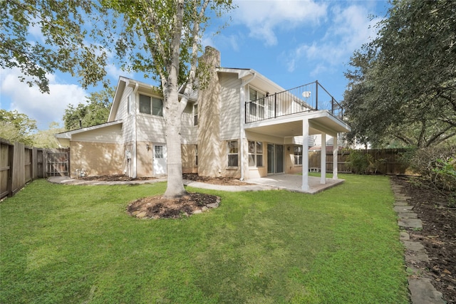 back of property featuring a lawn, a patio, and a balcony