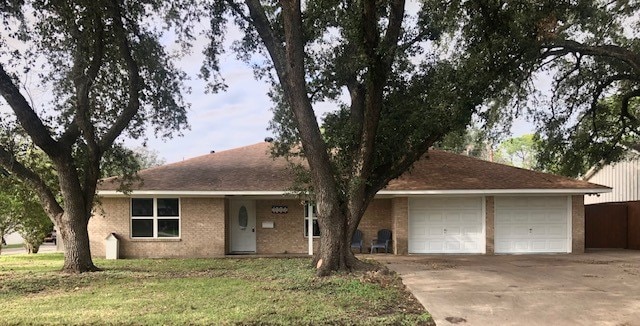 ranch-style house featuring a garage and a front yard