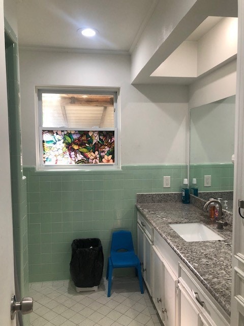 bathroom featuring tile walls, vanity, tile patterned floors, and crown molding