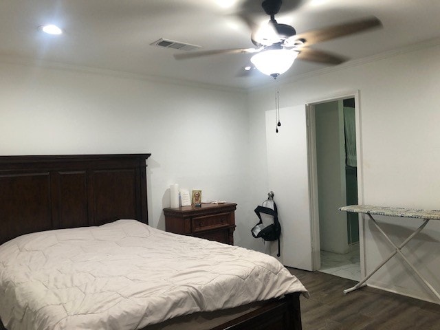 bedroom with ornamental molding, dark hardwood / wood-style flooring, and ceiling fan