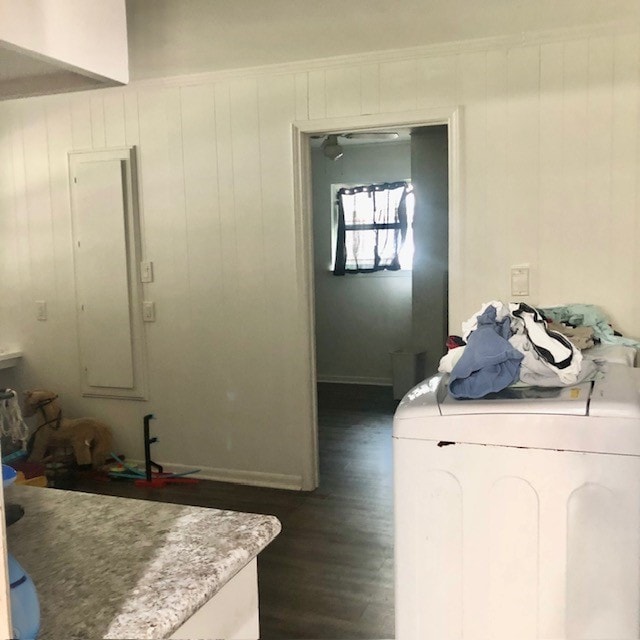 laundry area with dark hardwood / wood-style flooring, washer / clothes dryer, and wood walls