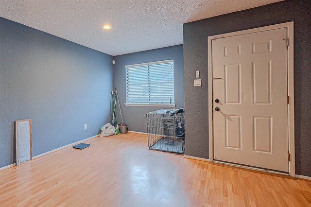 entrance foyer with a textured ceiling and light hardwood / wood-style floors