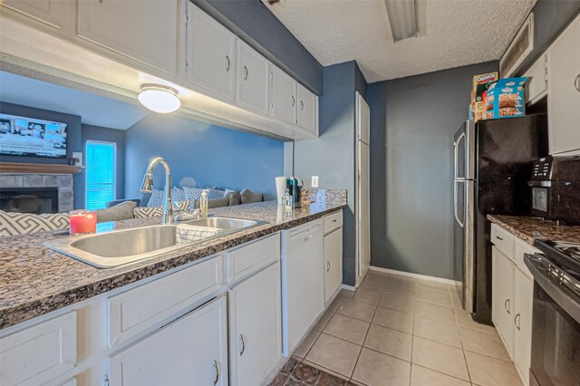 kitchen featuring light tile patterned flooring, white cabinetry, sink, stainless steel range, and dishwasher