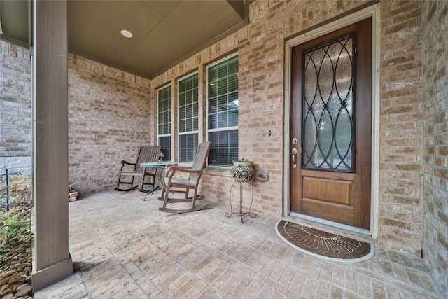 view of exterior entry featuring covered porch