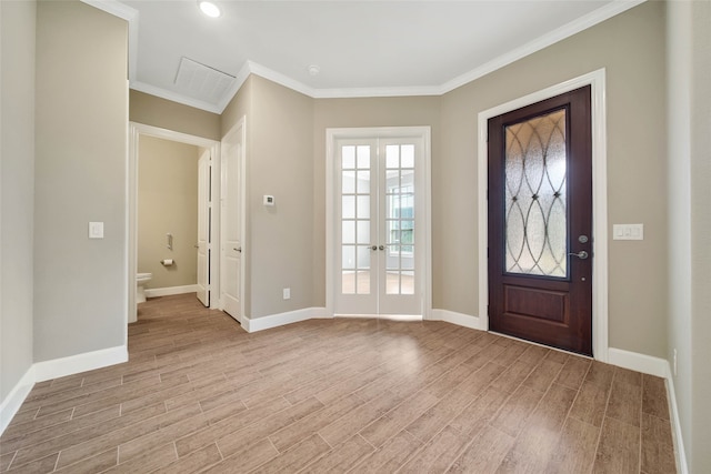 entrance foyer featuring ornamental molding, french doors, and light hardwood / wood-style floors