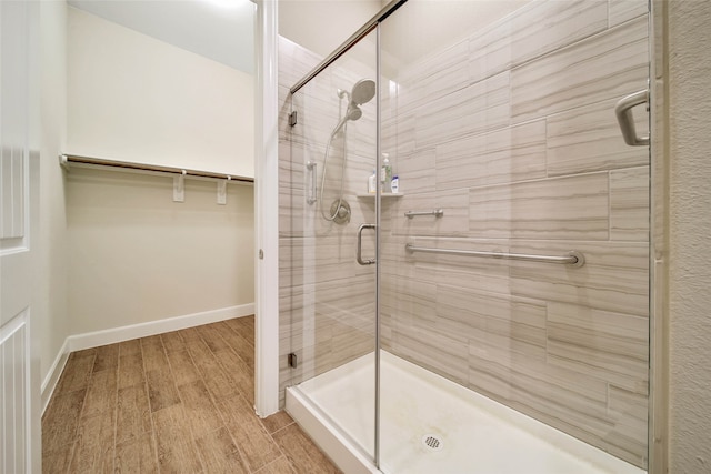 bathroom with hardwood / wood-style floors and an enclosed shower