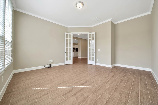 empty room with french doors, hardwood / wood-style flooring, and crown molding