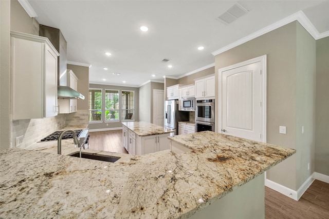 kitchen with white cabinetry, tasteful backsplash, a center island, and light stone countertops