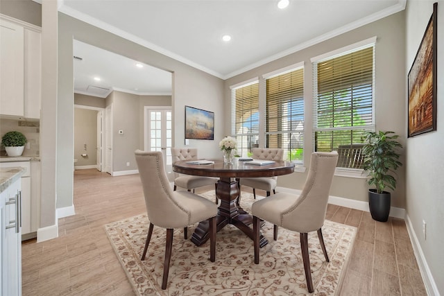 dining area featuring crown molding and light hardwood / wood-style flooring