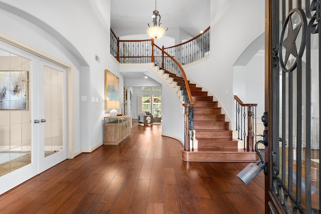 entrance foyer featuring french doors, dark hardwood / wood-style flooring, a notable chandelier, and a high ceiling