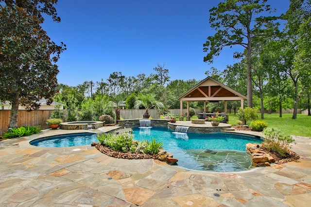 view of pool with a gazebo, a patio, pool water feature, and an in ground hot tub