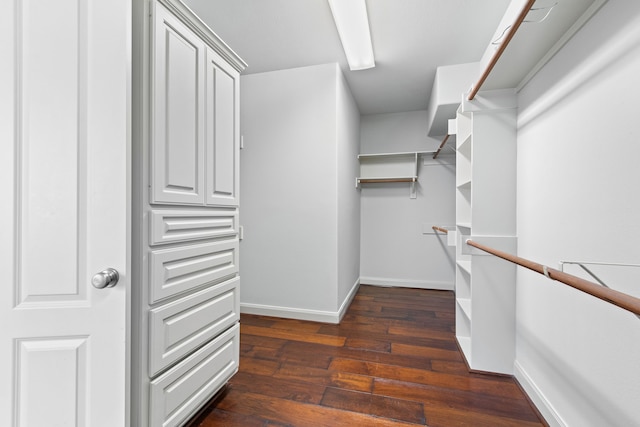 walk in closet with dark wood-type flooring