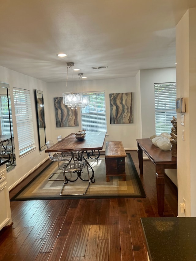 dining room with a chandelier, a healthy amount of sunlight, and dark hardwood / wood-style floors