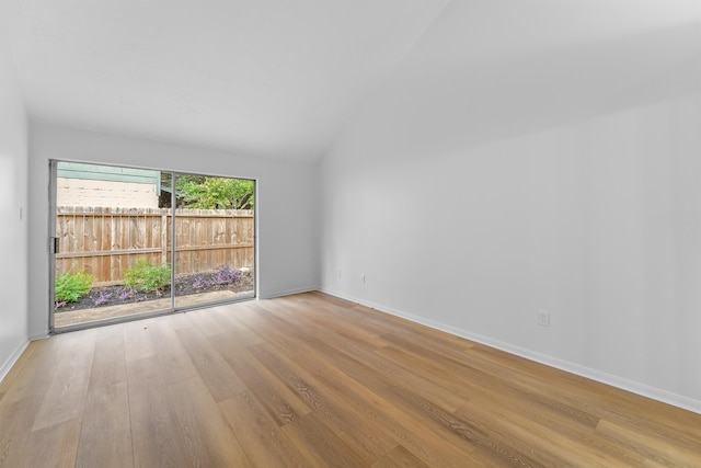 empty room with light wood-type flooring and high vaulted ceiling