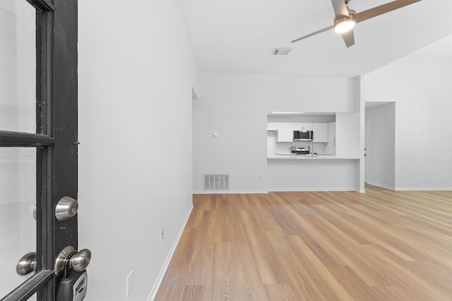 unfurnished living room with ceiling fan and light wood-type flooring