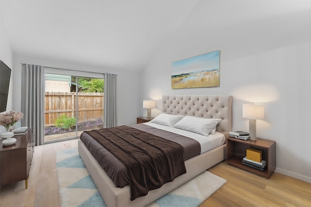 bedroom with access to outside, light hardwood / wood-style floors, and lofted ceiling