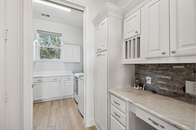 kitchen featuring white cabinetry, light hardwood / wood-style flooring, and independent washer and dryer