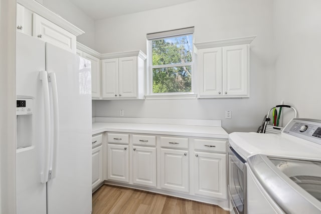 clothes washing area featuring cabinets, light wood-type flooring, and independent washer and dryer