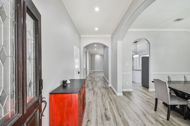 foyer entrance featuring light wood-type flooring and ornamental molding