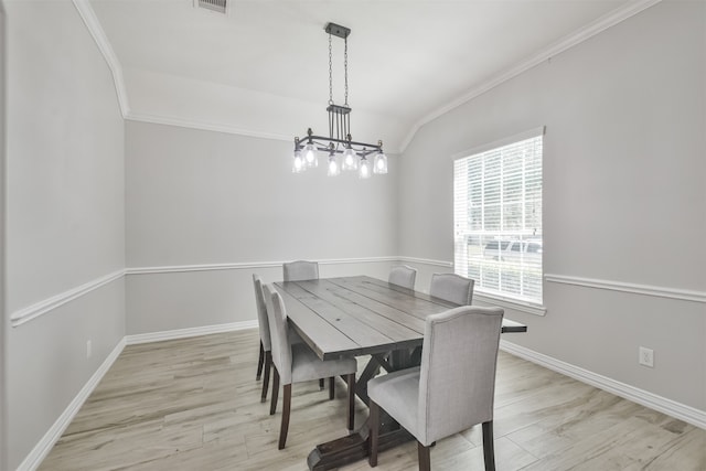 dining space with light hardwood / wood-style floors, a notable chandelier, and crown molding