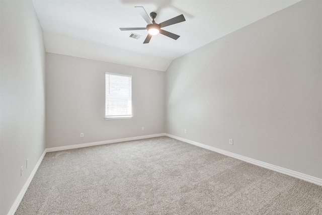 empty room featuring vaulted ceiling, carpet flooring, and ceiling fan