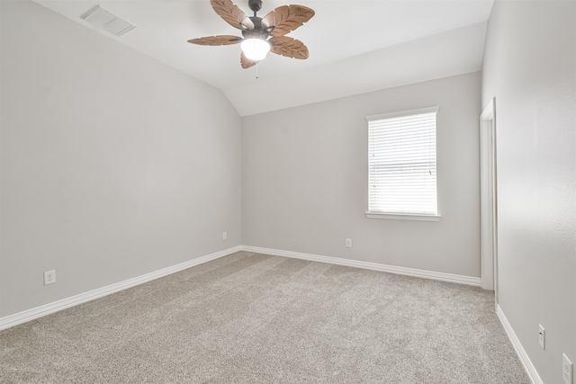 carpeted spare room featuring ceiling fan and vaulted ceiling