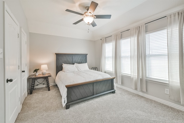 carpeted bedroom with ceiling fan and multiple windows