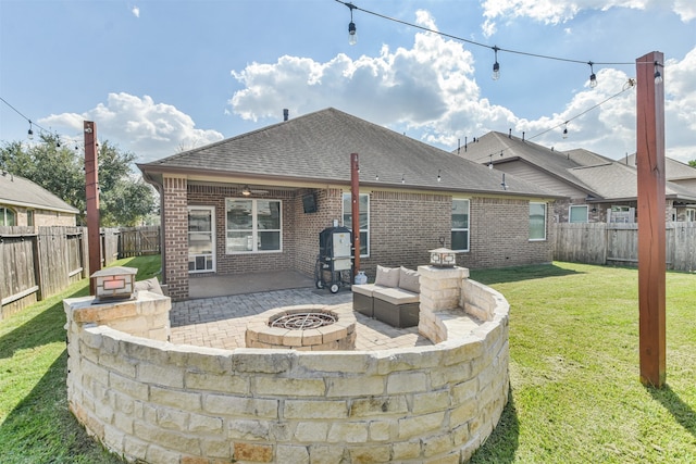 back of house featuring an outdoor fire pit, a yard, and a patio area