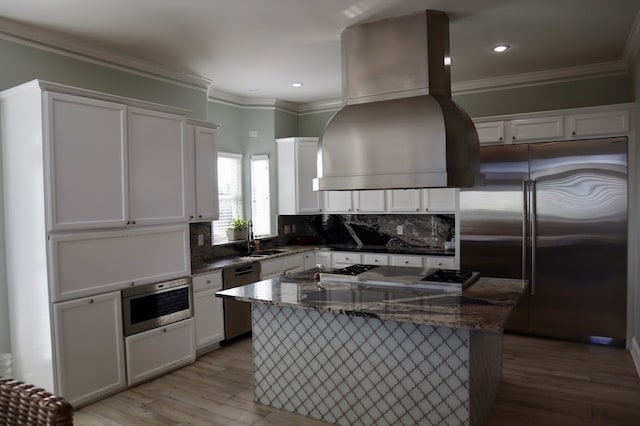 kitchen featuring white cabinetry, light wood-type flooring, stainless steel appliances, and range hood