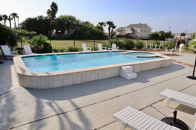 view of swimming pool featuring an in ground hot tub and a patio area