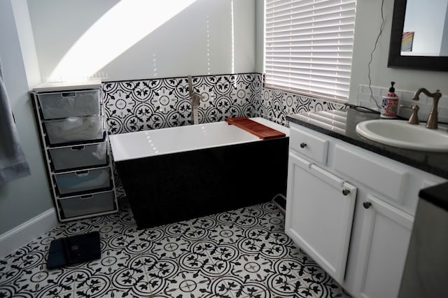 bathroom with a bathing tub, tile patterned flooring, and vanity