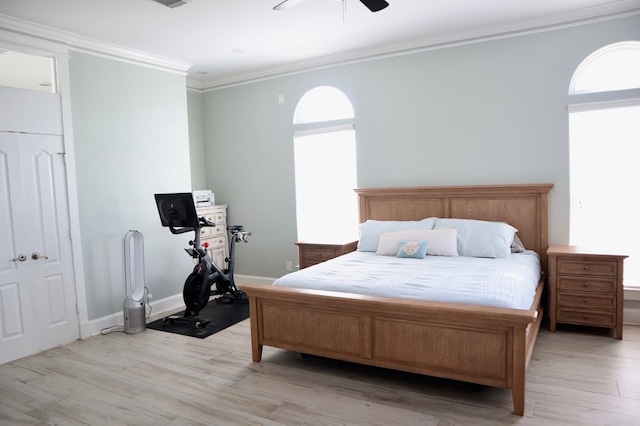 bedroom with crown molding, light hardwood / wood-style floors, multiple windows, and ceiling fan