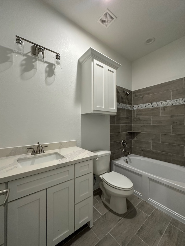 full bathroom featuring vanity, toilet, and tiled shower / bath combo