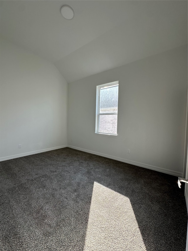 additional living space featuring vaulted ceiling and dark carpet