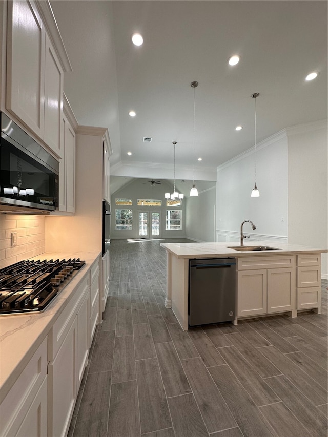 kitchen with hanging light fixtures, appliances with stainless steel finishes, sink, and white cabinets