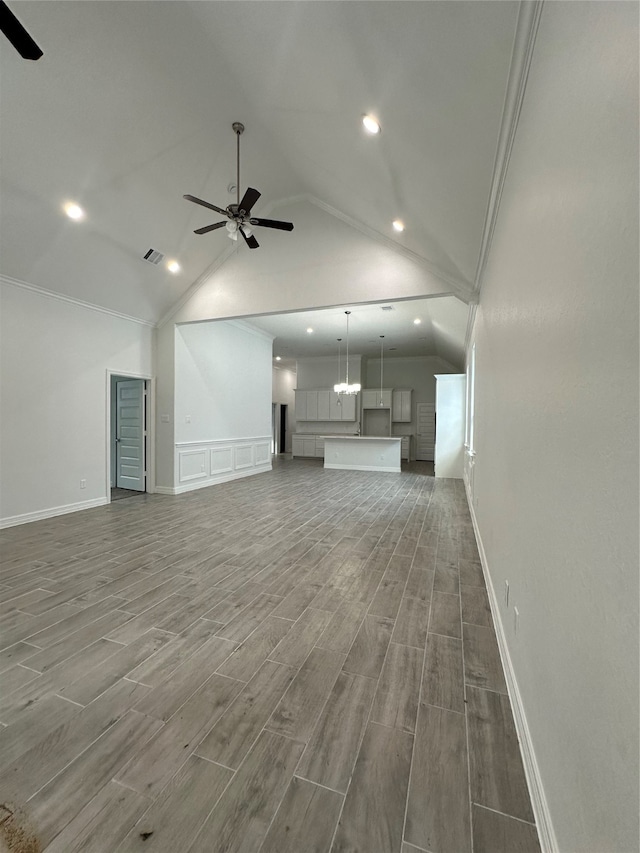 unfurnished living room featuring ceiling fan, vaulted ceiling, and wood-type flooring